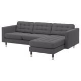 Modern dark grey l-shaped sofa with tufted seats. Steel legs, sleek design.