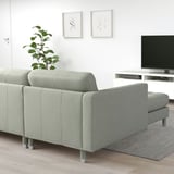 Light green modern sofa, minimalist room with tv; clean and cozy design.
