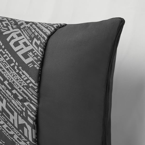 A transforming cushion with a geometric pattern, shown folded with a smooth, soft texture and sturdy zipper.