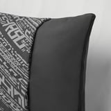 A transforming cushion with a geometric pattern, shown folded with a smooth, soft texture and sturdy zipper.