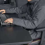 Person sitting, typing on keyboard, wearing a convertible blanket-sweatshirt.