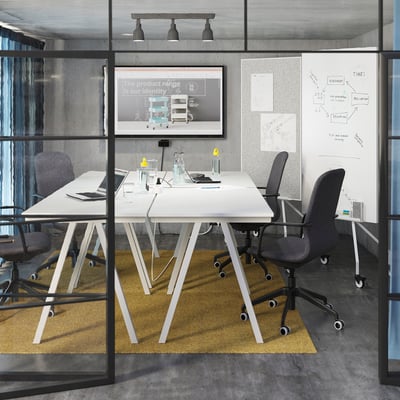 Modern conference room with LÅNGFJÄLL grey chairs, white table, large screen, and whiteboard.
