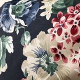 Floral cushion close-up: vibrant flowers, dark background, intricate details, high-quality cotton.