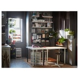 Office space with white table, black chairs, and shelves against dark wall, near window with plants.