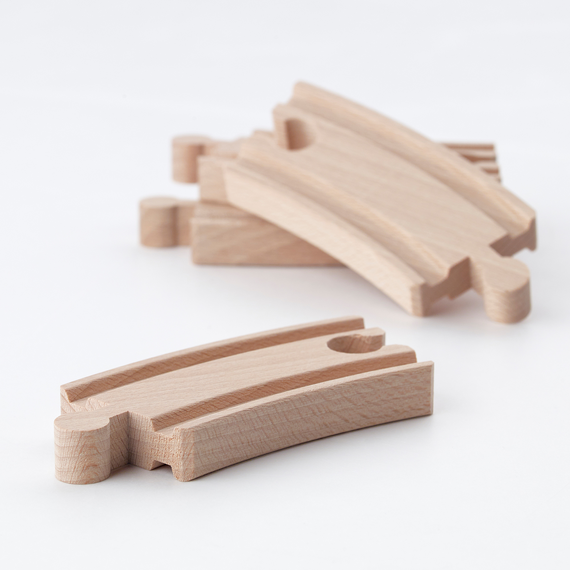 Set of light-colored wooden train tracks, neatly arranged for assembly.