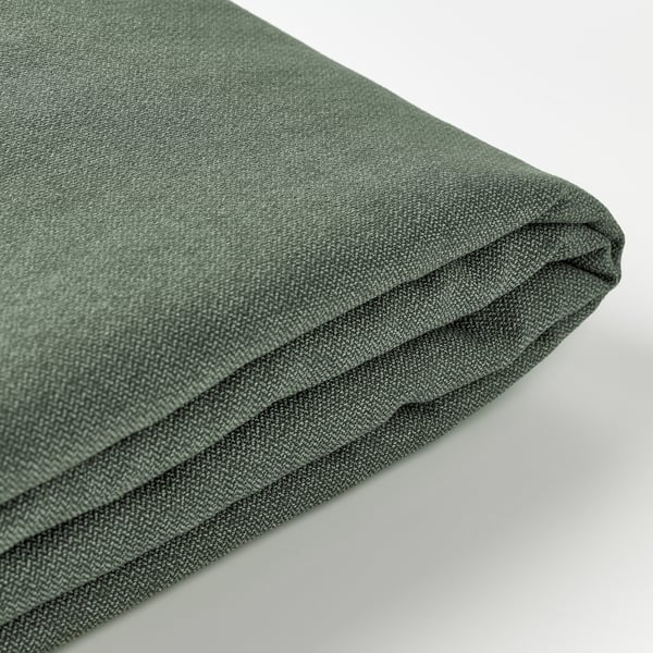 Textured green fabric folded neatly, displaying subtle herringbone pattern and soft touch.