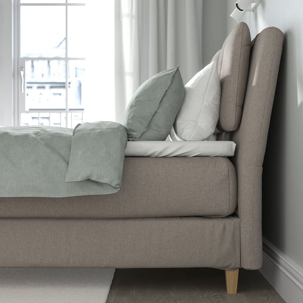 A modern bed with a cushioned headboard, providing comfort and style.