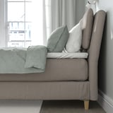 A modern bed with a cushioned headboard, providing comfort and style.