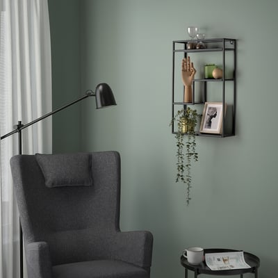 Cozy reading nook with LINDÅSEN shelf, books, plants, lamp, and mug.