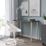 Modern home office with black LINNMON desk, adjustable white chair, lamp, zebra artwork, and a plant.