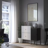Modern living room with LIXHULT storage, metal accents, & gray walls. Large window, wooden floor, plant, lamp, & art.