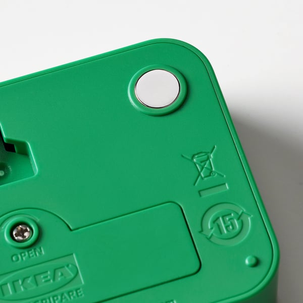 Close-up of green LJUNGPIPARE clocks back, featuring magnet and recycling symbols.
