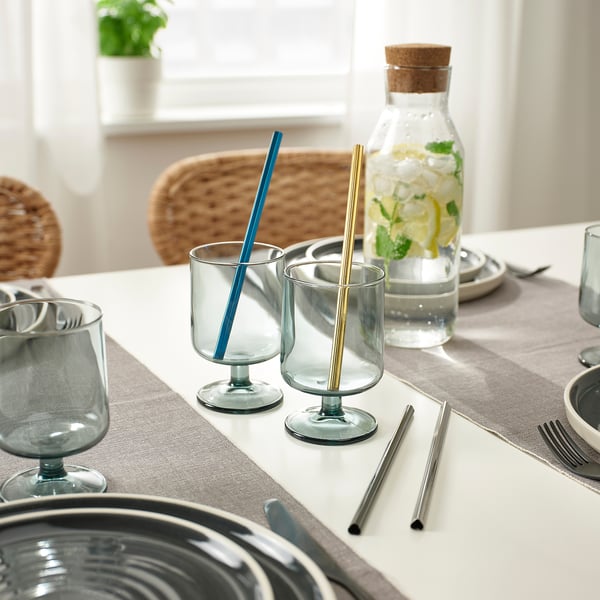 Table set with clear glasses, stainless steel straws, and a pitcher of lemon water.