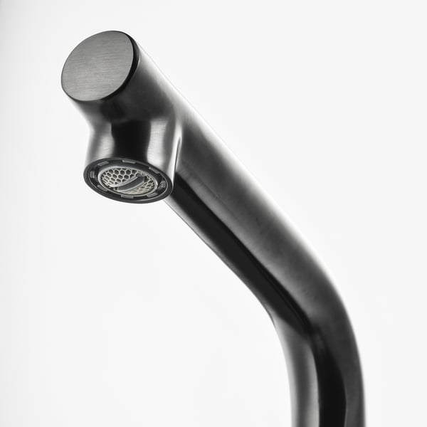 Modern metallic faucet with sleek, curved spout and textured, honeycomb-patterned nozzle.