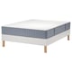 White LYNGÖR bed base with light blue mattress, featuring wooden legs, flat slats, and unique double layer of pocket springs for comfort and support.