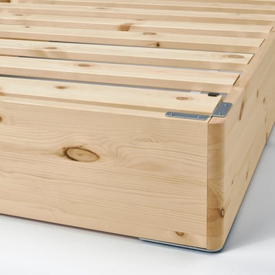 Close-up of wooden pine bed base with sturdy metal connectors, showcasing high-quality craftsmanship and supportive design.