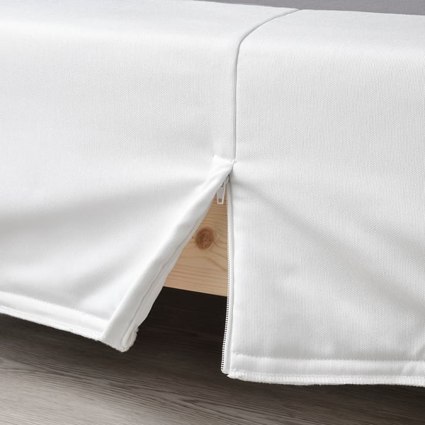 A white LYNGÖR mattress base with a removable, washable cover and flat slats supporting a spring core.