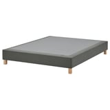 Grey upholstered bed base on wooden legs, rectangular shape, simple design.