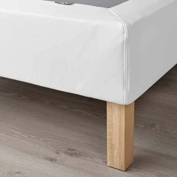 Close-up of LYNGÖR bed base corner, showing flat slats supporting mattress, with wooden legs.
