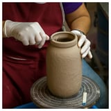 Shaping clay on wheel for vase