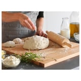 Baker rolls dough with wooden pin, assembling pastry.