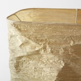 Close-up of intricate, gold-toned textured lamp shade.