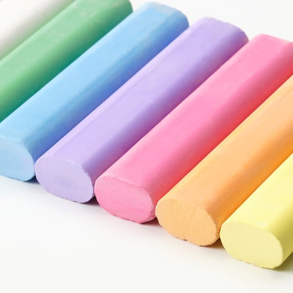 Six vibrant, large pastel-colored chalks neatly arranged in a row, showcasing their smooth texture and bright hues, ideal for drawing.
