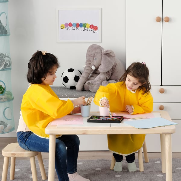 Kids drawing at table with toys.