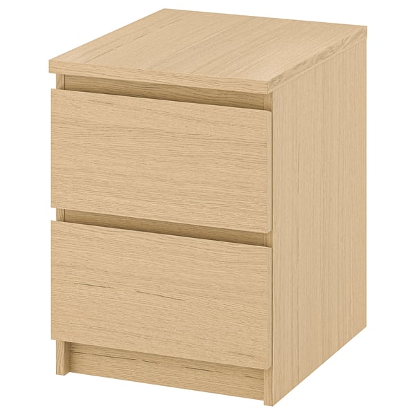 An ikea MALM light brown wooden nightstand with smooth drawers.