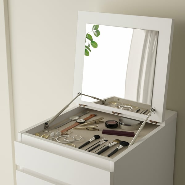 Open white vanity with mirror, jewelry, watches, and makeup on top.