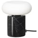 The MARKFROST lamp a black marble base and a frosted glass shade, emitting warm, soft light.
