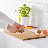 Person chops onion on wooden cutting board in kitchen.