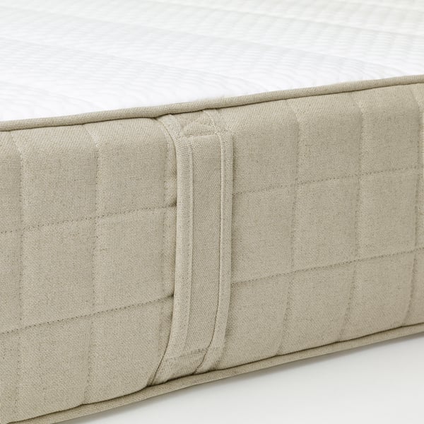 Close-up of a high-quality mattress showcasing its natural, textured linen cover and supportive foam interior.