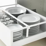 Organized kitchen drawer with white plates, bowls, and glass jars. MAXIMERA drawer system pulls fully out with a soft-close feature.