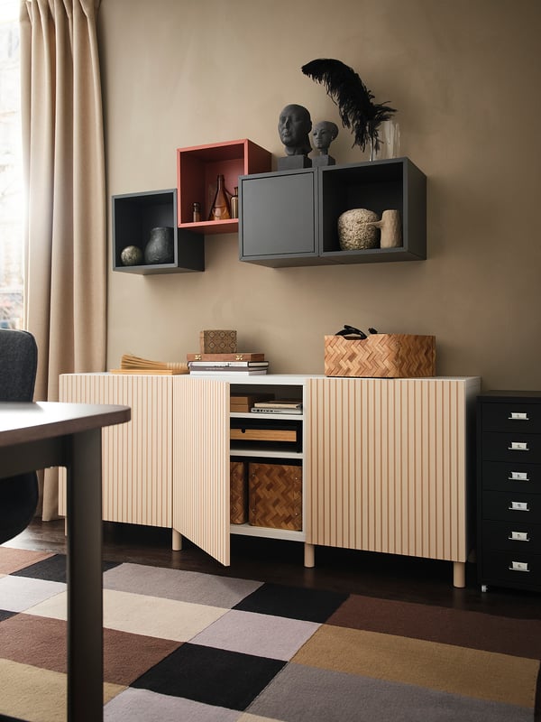 Modern room with MEJARP storage units: light wooden cabinet, black shelves, decorative items, colorful rug.