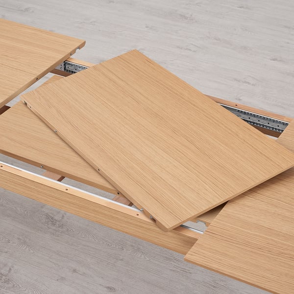 Wooden table leaves with metal rails, showing extension mechanism for table expansion.