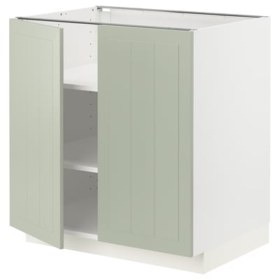 A METOD kitchen cabinet in green with light gray shelves. The cabinet two doors with panel design and adjustable shelves.
