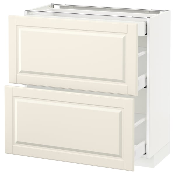 A white METOD kitchen cabinet with off-white bodbyn drawers featuring beveled edges.