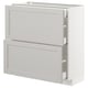 A white METOD kitchen cabinet unit with two drawers and a door, featuring a classic design with bevelled edges.