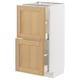 METOD kitchen cabinet with oak veneer doors, white frame, and silver handles.