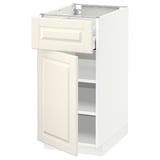 A white METOD kitchen cabinet with a drawer and open door, featuring beveled edges and adjustable shelves.