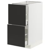 Modern kitchen unit with black drawers in a white cabinet, sleek design.