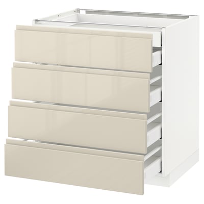 A white IKEA METOD kitchen cabinet with four high-gloss beige drawers. The drawers are sleek and modern with integrated handles.