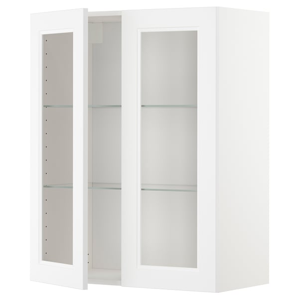 A white METOD kitchen cabinet with glass doors and adjustable shelves.