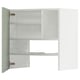 Displays a white METOD kitchen cabinet with green fronts, featuring shelves and adjustable storage.