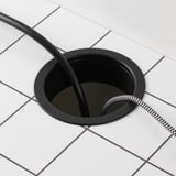 Image depicts a black floor box with cables, typically used for organizing and hiding wires and cables in a tiled floor.