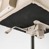 Close-up of a stylish office chairs mechanism, showcasing its sturdy beige plastic and metallic components, ensuring stability and comfort.