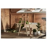 Wooden desk setup with white tabletop and light-colored legs. Includes plants and paper on the table.