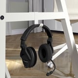 A black headset with microphone hangs on a white desks side hook.