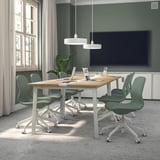 Conference room with MITTZON tables and långfjäll chairs, green walls, tv, and large windows.